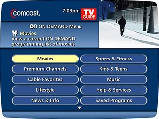 Comcast on-screen guide welcome screen: the ON DEMAND menu with Movies highlighted and ten category buttons including Premium Channels, Kids & Teens, Music and Saved Programs, with a live video window in the upper right